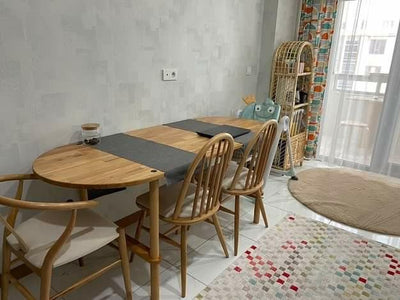 Yemek odasında uzun ahşap yemek masası, çevresinde ahşap sandalyeler ve minderli bank