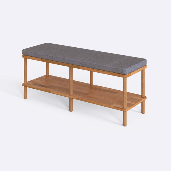 Waljan Bench 120 x 38, gri keten döşemeli oturum ve masif kayın gövde, beyaz zeminde üç çeyrek açıdan stüdyo çekimi
