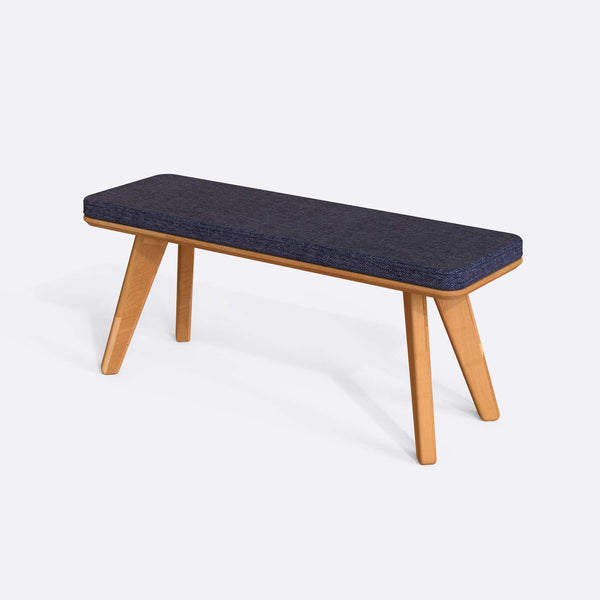 Han Bench 120 x 38, lacivert keten döşeme, masif kayın gövde, beyaz zeminde üç çeyrek açıdan çekim