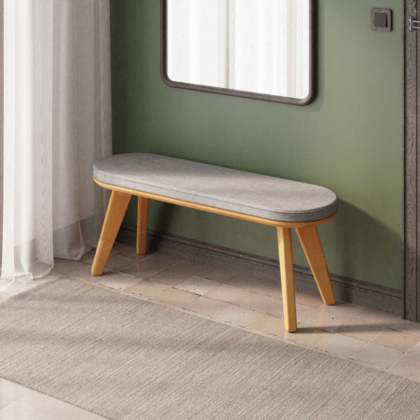 Yase Bench 120 x 38, gri keten döşemeli oturum ve masif kayın gövde, döşenmiş oda ortamında kullanım görünümü