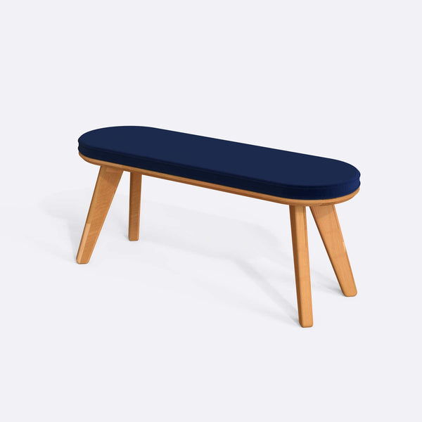 Yase Bench 120 x 38, lacivert kadife döşemeli oturum ve masif kayın gövde, beyaz zeminde üç çeyrek açıdan stüdyo çekimi