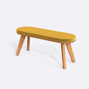 Yase Bench 120 x 38, sarı kadife döşemeli oturum ve masif kayın gövde, beyaz zeminde üç çeyrek açıdan stüdyo çekimi