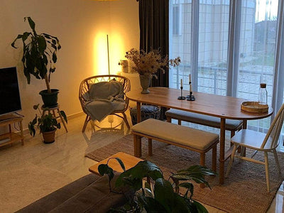 Bitkilerle dolu salonda oval masa, bench ve halka sandalye