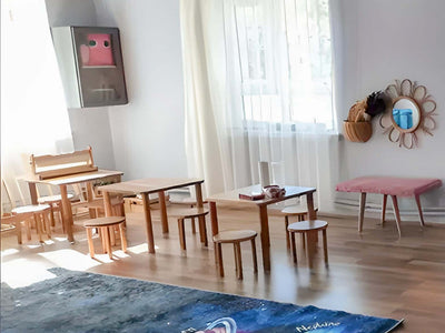Çocuk odasında sıra sıra dizilmiş minyatür ahşap masa ve sandalyeler