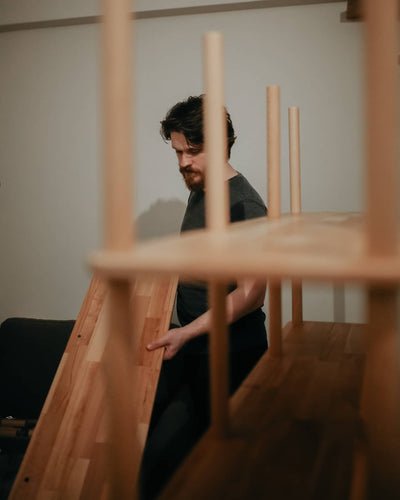 Ahşap kitaplığın dikey çubuklarını yerine yerleştiren kişi