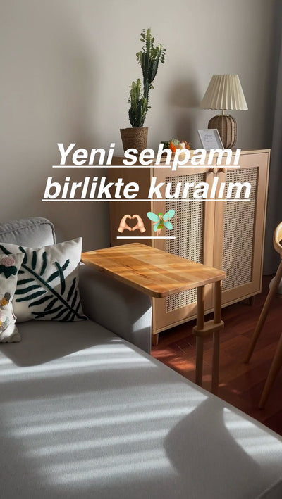 Pencere önünde yeni kurulmuş ahşap yan sehpa; üzerinde saksıda kaktüs